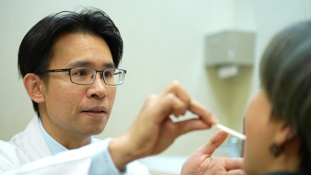 蔡明劭醫師在門診為患者進行鼻腔與口咽檢查，評估睡眠呼吸中止症的呼吸道阻塞情形
